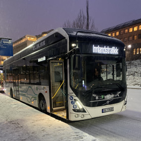 Hvit buss i snøvær 