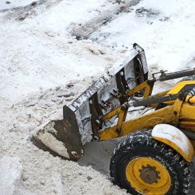 Gul gravemaskin som maaker sno